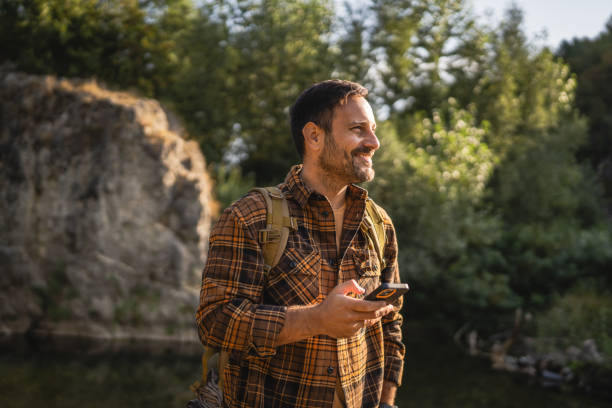 istock Adult man explore nature while check mobile phone in a serene setting 2171576200