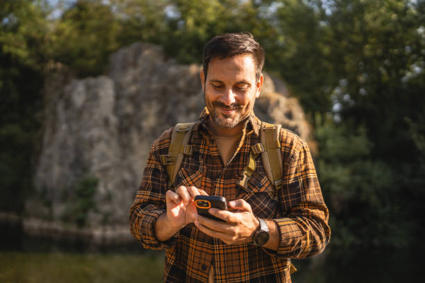 istock Adult man explore nature while check mobile phone in a serene setting 2171576413