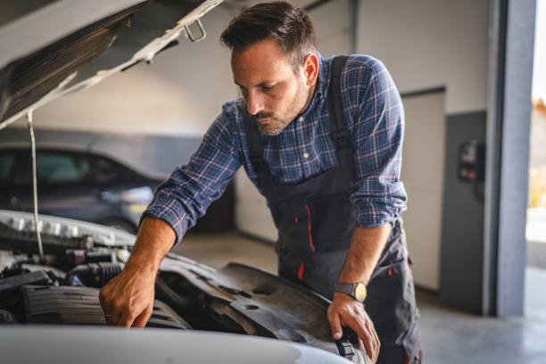 istock Car mechanic work under car hood in garage, maintaining vehicle engine 2171576480