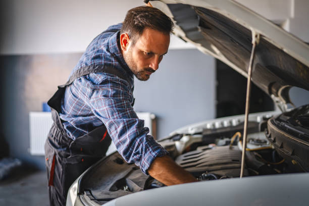 istock Car mechanic work under car hood in garage, maintaining vehicle engine 2171576481