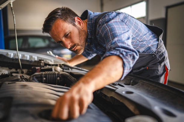 istock Focused car mechanic work under car hood in a garage setting 2171576665