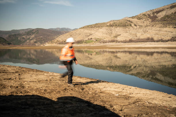 Mature man work day at hydroelectric dam. Ecology oriented research on innovation of the equipment.