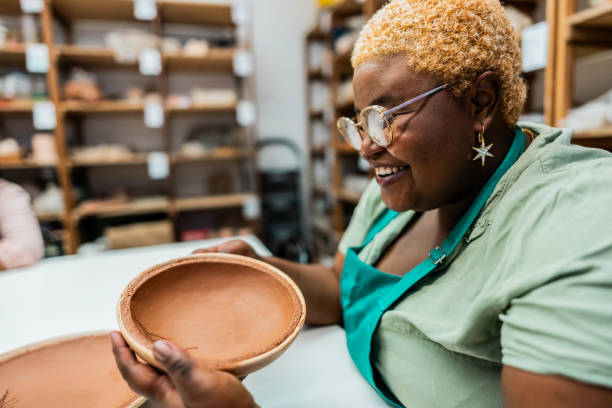 istock Young woman looking a craft product at ceramics workshop 2171608592