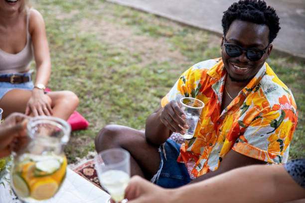 Young People relaxing with drink and talk in the backyard on Summer day