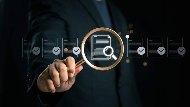 istock Businessman holding a magnifying glass, showing Audit Document concept,quality assessment management With a checklist, business document evaluation process, market data report analysis and consulting 2171612854