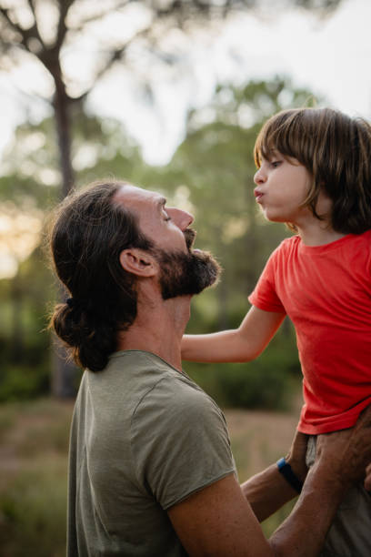 istock Boy blows on his father's face to cool him down from the intense heat 2171614689
