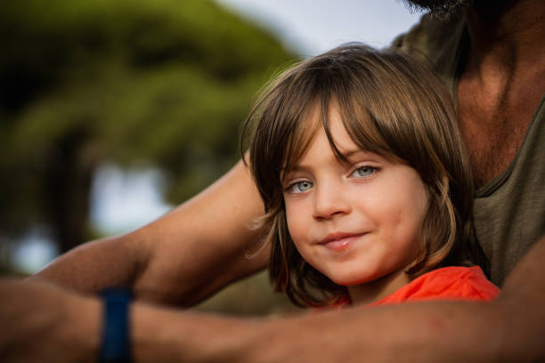 istock Young boy smiling sitting with father outdoors 2171614692