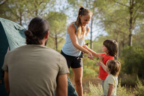 istock Happy family setting up tent while camping in forest 2171614705