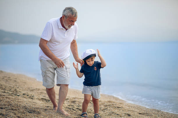 istock Grandfather running on the beach with grandson 2171615599