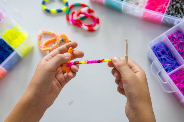istock Child making colorful rubber band bracelet with a loom tool 2171615807