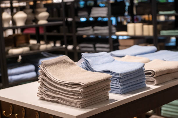 istock Stacks of beige and blue towels displayed on a table in a store. 2171615820