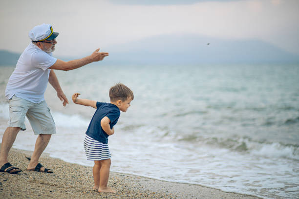 istock Happy kid playing on the beach with his grandfather 2171615835