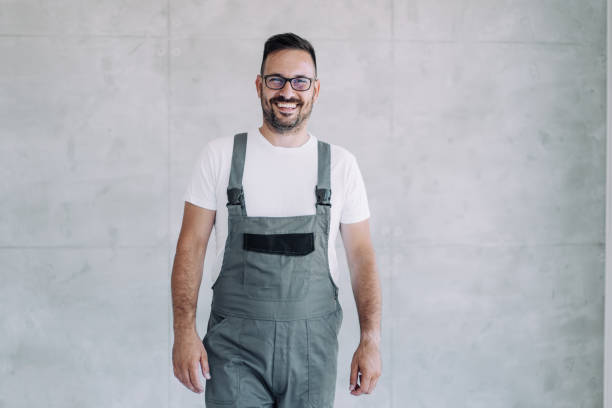 istock Young male worker in an overall uniform posing at his workplace. 2171616677