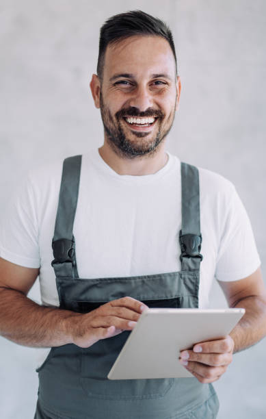 istock Young male worker in an overall uniform using tablet at his workplace. 2171616679
