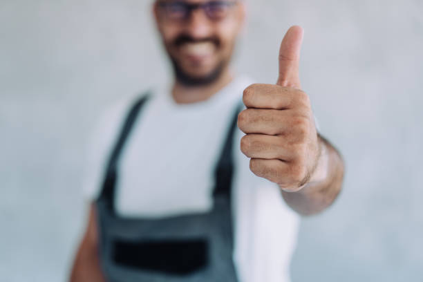 A cheerful and skilled construction worker holds a measuring tape in readiness for an important project ahead