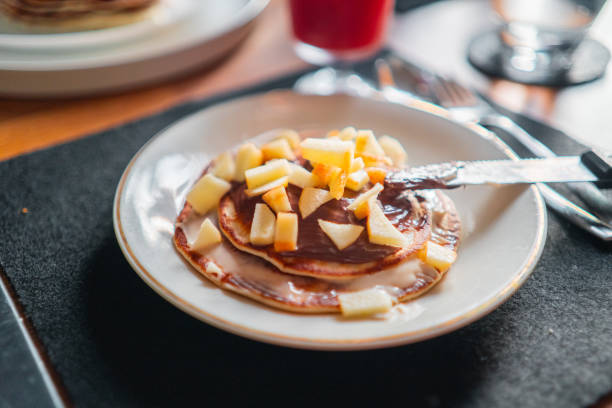 istock Pancakes with Apple Slices Covered wiht Choclate Cream on a Plate 2171619608