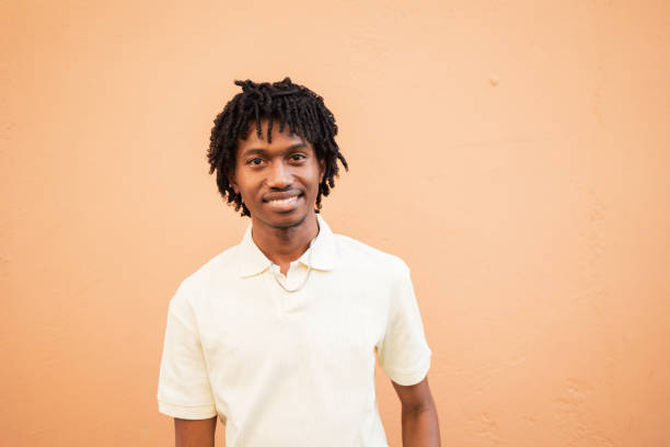 istock Smiling man in white shirt against peach background wall 2171619940