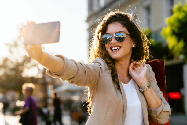 istock Smiling Woman Taking Selfie During Shopping Excursion 2171620719