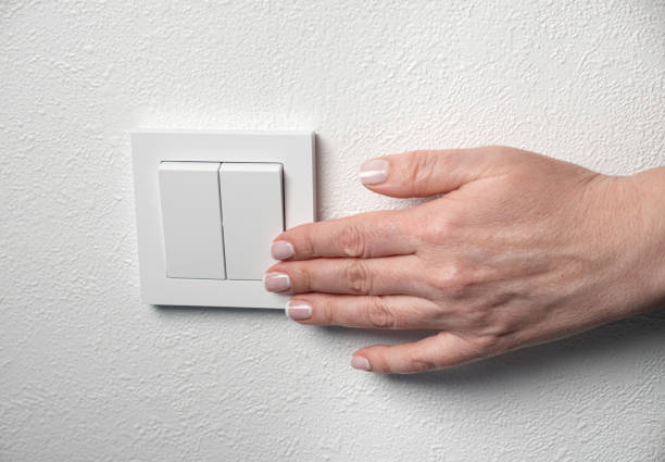 istock Woman switch on the light at home. Female hand push button on wall 2171620765