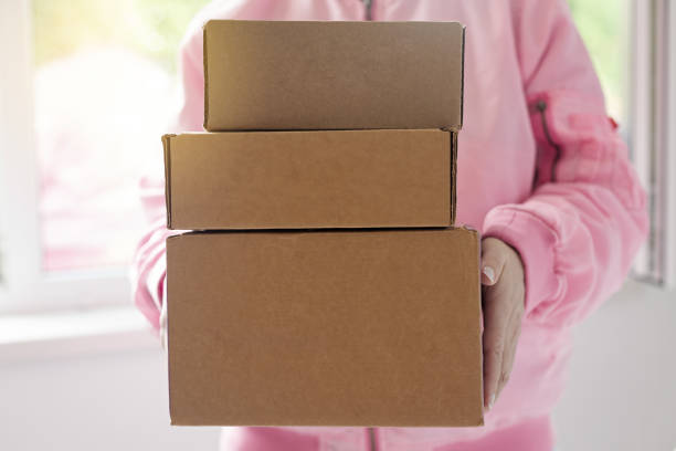 Copy space shot of unrecognizable female business owner carrying a labeled package that she prepared for shipping.