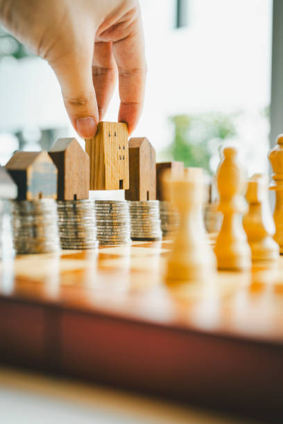 istock Chess, stack of coins and house models in chess game, competition success play. strategy, management or leadership concept 2171633881