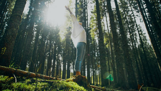 istock Joyful Woman Embracing Nature on Forest Tree Stump 2171639511