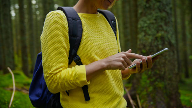 istock Caucasian Female Hiker Navigates with Smartphone in Forest 2171639559