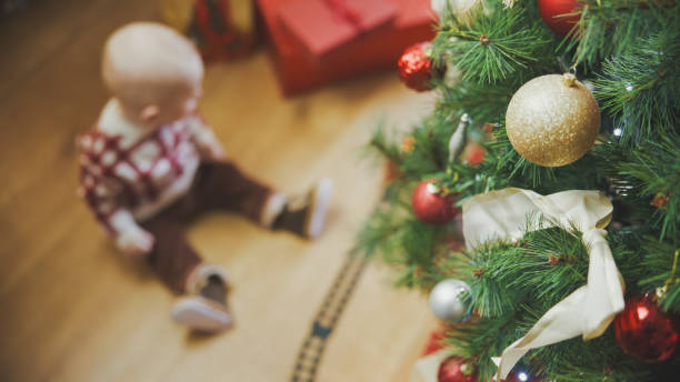 istock Curious Baby Watching Train by Christmas Tree 2171639785