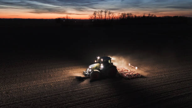 Nighttime Farming with Tractor in Field