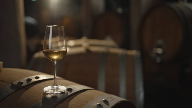 istock Elegant White Wine Glass on a Rustic Barrel in a Cellar 2171640193