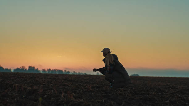 istock Caucasian Female Farmer Evaluating Soil Quality at Dawn 2171641806
