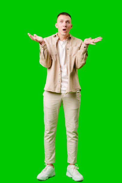 istock Cheerful Young Man Posing With Outstretched Hands Against a Bright Green Background 2171653196