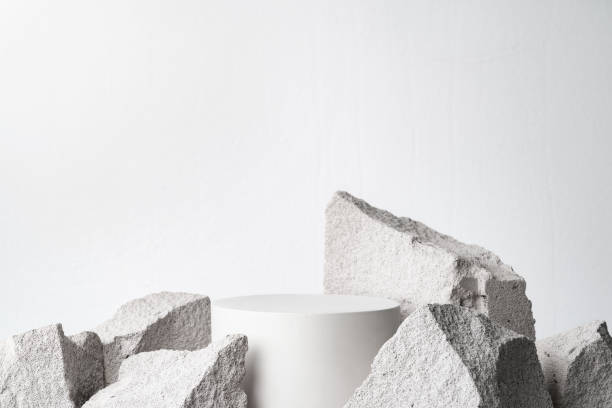 istock A minimalistic display featuring a smooth white cylinder surrounded by rough gray stone fragments 2171656041