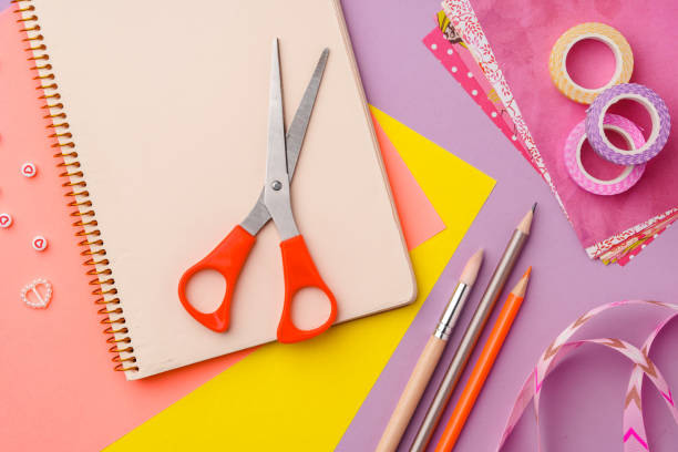 istock Scissors and decorative tape on colorful craft paper in a bright workspace 2171657459