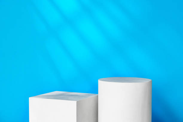 istock White geometric shapes on a clean surface against a bright blue background with soft shadows 2171657874