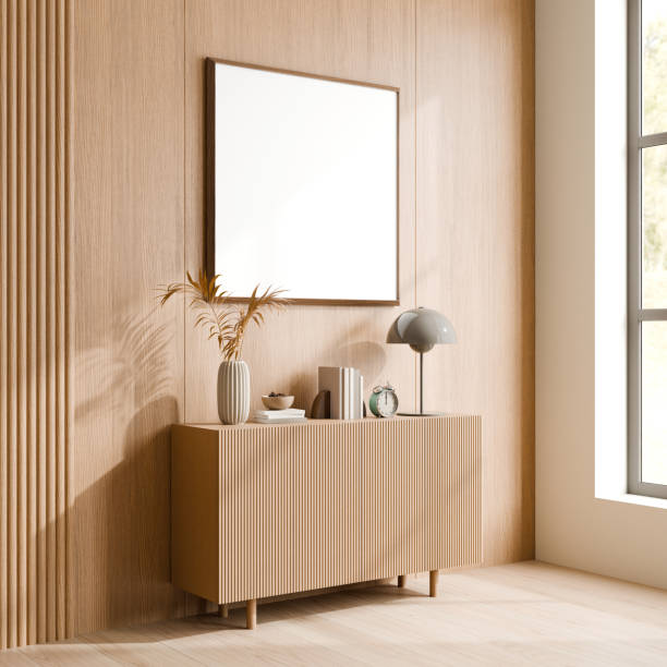 istock A modern minimalist interior featuring a sleek wooden sideboard, miscellaneous decor items, and blank square picture frame. 3d render. 2171660701