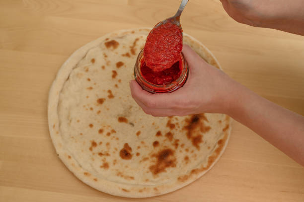 istock Tomato sauce for pizza, spread the sauce on the dough 2171661825