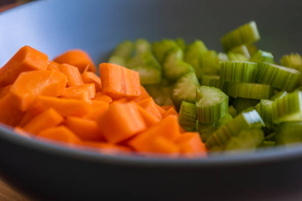 Chopped Carrots and Celery in a Blue Bowl for Soup Base Preparation Close-Up