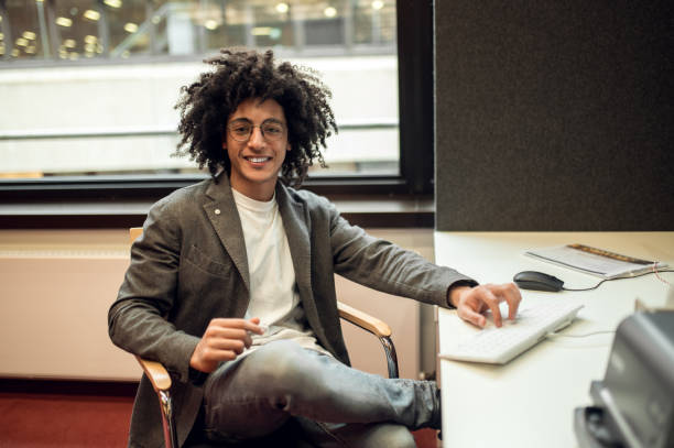 istock Young curly-haired businessman in the office looking confident 2171664015