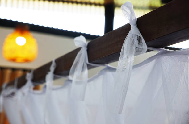 istock Mosquito net hanging in ribbons on wooden bedframe 2171665284