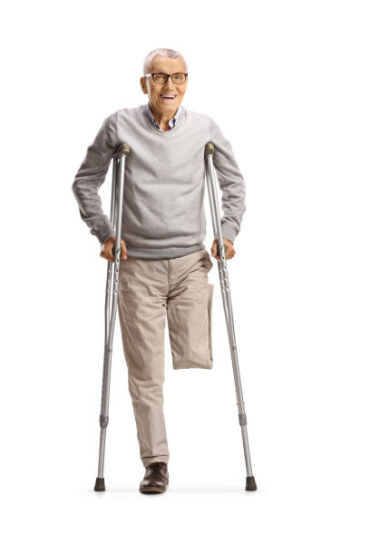Elderly man with amputated leg standing with crutches isolated on white background