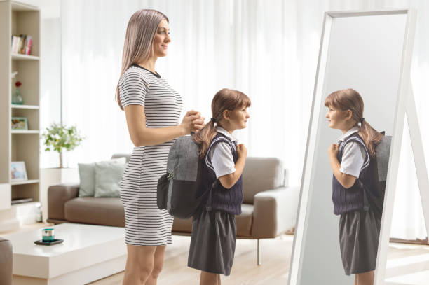 istock Mother and child in a school uniform getting ready in front of a mirror 2171667131