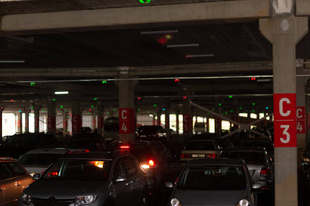 Low aerial photo of a car in long exposure, leaving trails of light behind next to parking cars