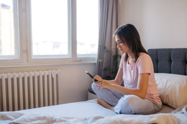 istock Young Woman Using Phone After Waking Up In The Morning 2171669688