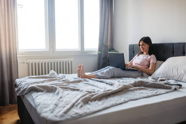 istock Young Woman Working On The Laptop From Her Bed 2171671500