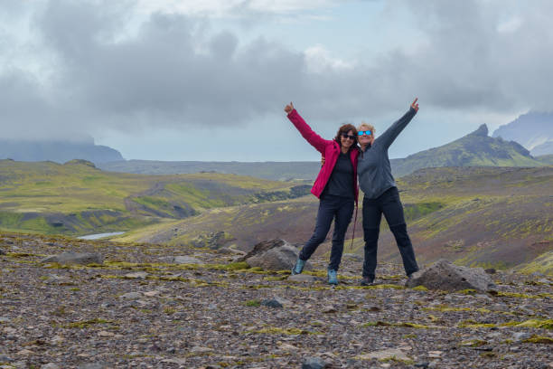 istock Two women celebrating on rocky landscape with mountain view 2171676825