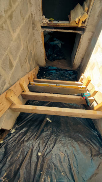 istock Construction of a bomb shelter. Making wooden formwork for pouring concrete steps into the shelter. 2171676956