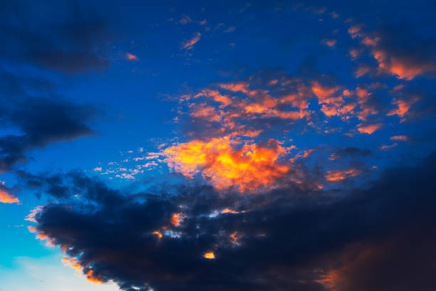 Sky is blue with a few clouds and the sun is setting. Clouds are orange and pink, creating a warm and peaceful atmosphere