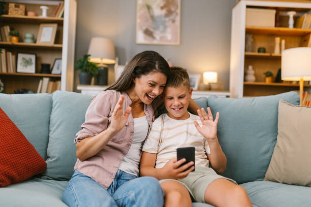 istock Mother and Son Waving During a Video Call on the Sofa 2171682257