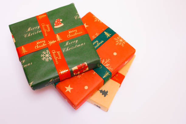 Three Christmas gifts of various colors placed stacked on a white background, Christmas gifts and Christmas season concept